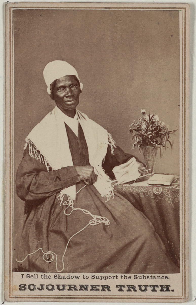 Black-and-white photograph of Sojourner Truth seated by a small table